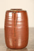 A studio pottery vase with khaki glaze and drip overglaze